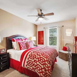 Large bedroom with transitional furniture and bright red bedding