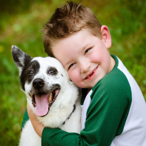 Boy missing two-front teeth hugging his dog